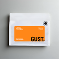 A white coffee bag with a prominent orange label reading 'URAGA ETHIOPIA' and 'GUST.' on a gray background.