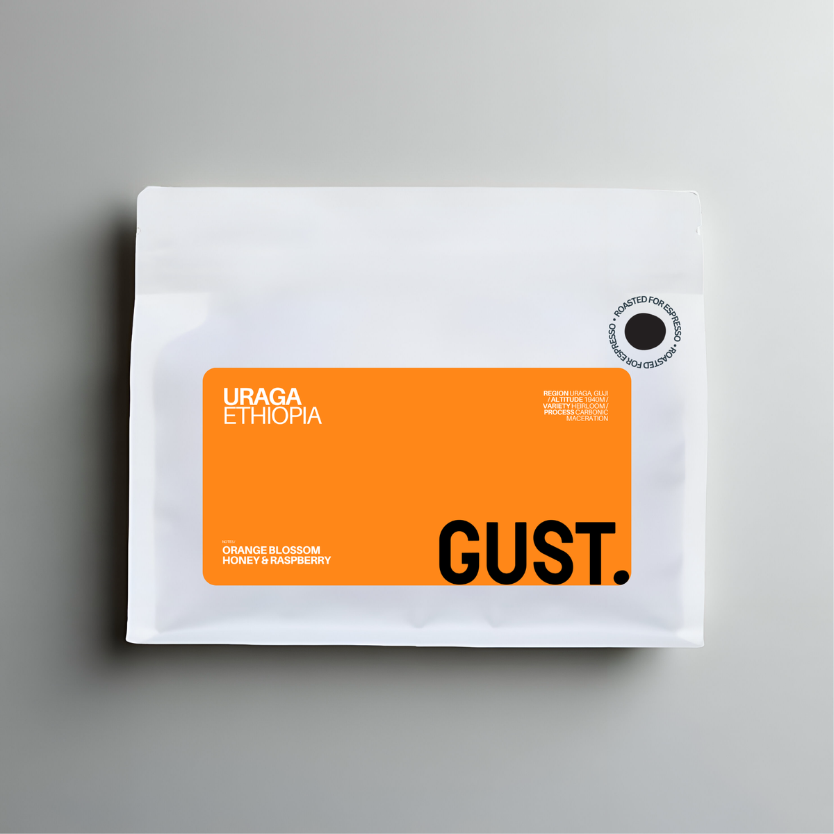 A white coffee bag with a prominent orange label reading 'URAGA ETHIOPIA' and 'GUST.' on a gray background.