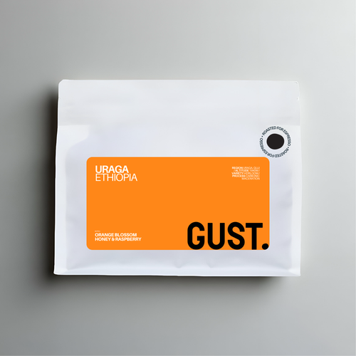 A white coffee bag with a prominent orange label reading 'URAGA ETHIOPIA' and 'GUST.' on a gray background.